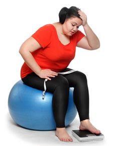 Overweight woman with a weighing machine and measure tape.