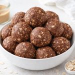 chocolate peanut butter protein balls stacked in a bowl