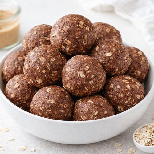 chocolate peanut butter protein balls stacked in a bowl