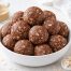 chocolate peanut butter protein balls stacked in a bowl