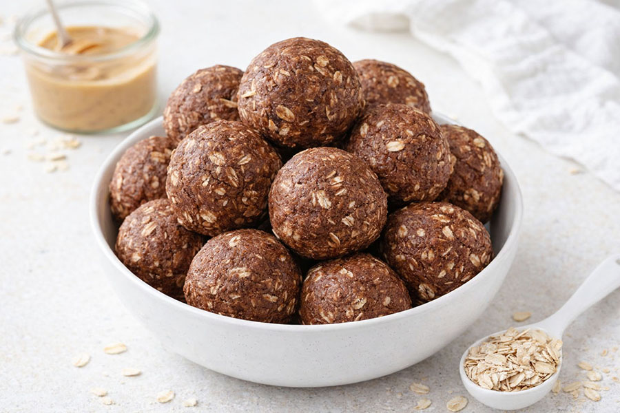 chocolate peanut butter protein balls stacked in a bowl