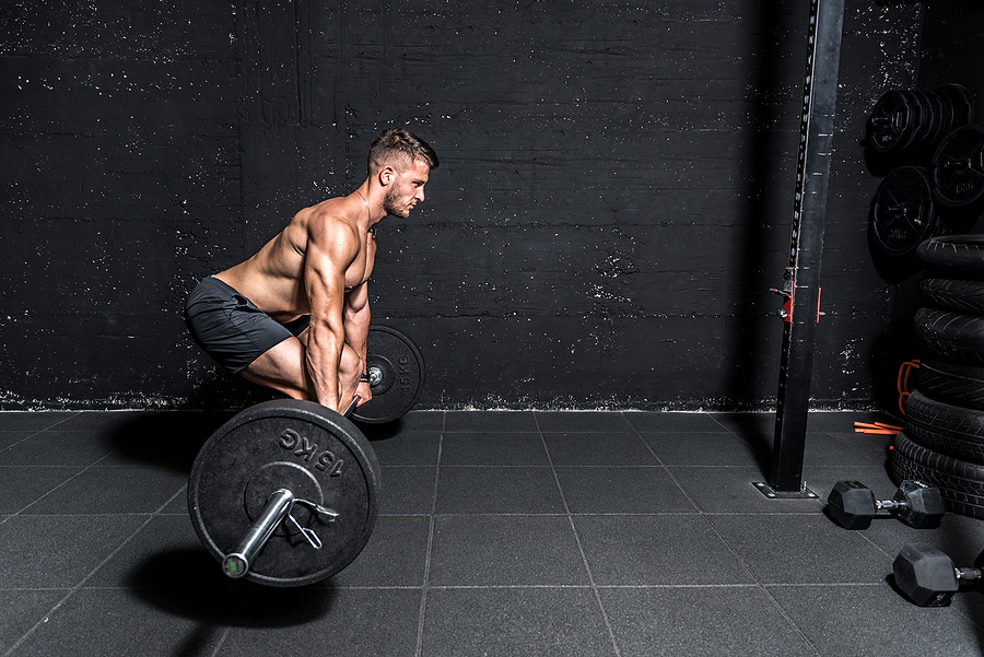 Man deadlifting in minimalist gym