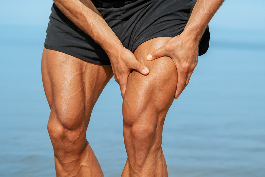 Man holding his thigh muscle, rubbing his leg due to delayed-onset-muscle soreness (DOMS)
