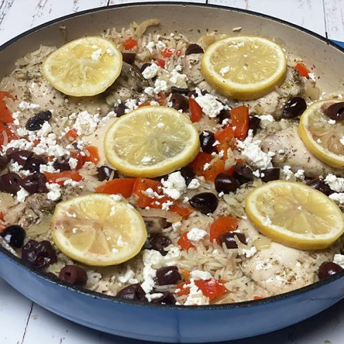 Greek chicken and rice with lemon slices in casserole dish