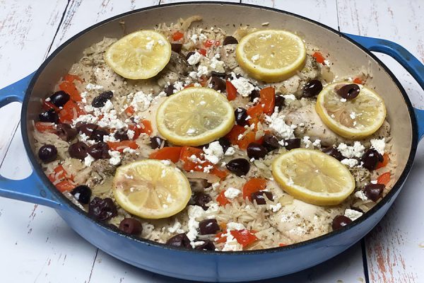 Greek chicken and rice with lemon slices in casserole dish