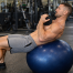 Man training abs with weight on stability ball