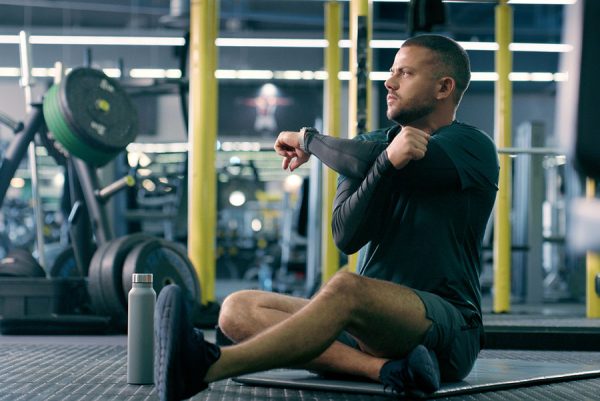 man in gym doing upper body warm up before lifting