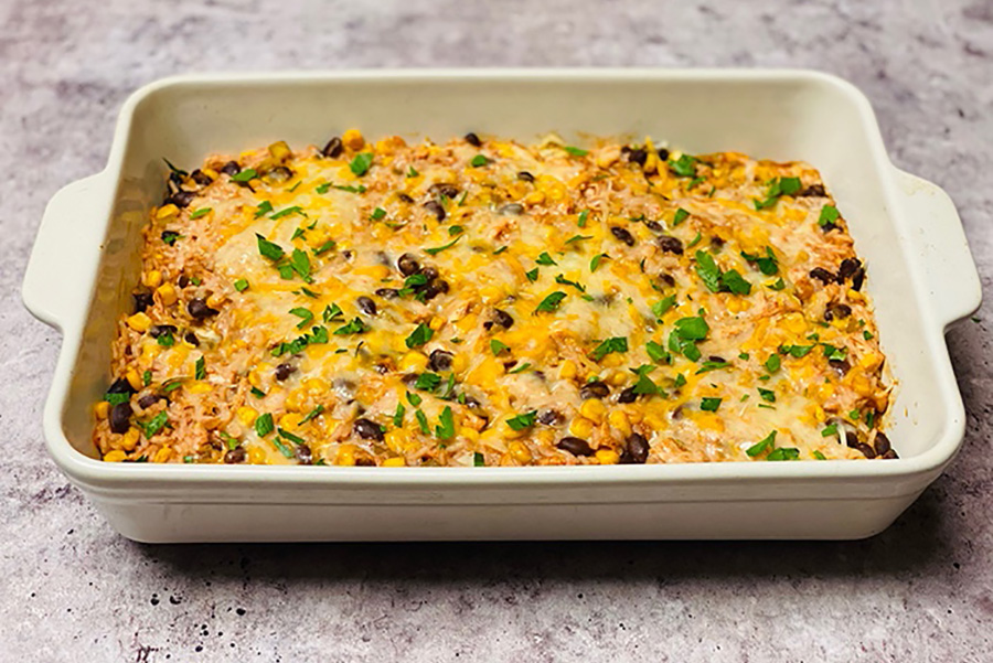 high protein chicken enchilada bake in casserole dish